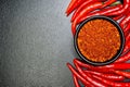 Red chili peppers and chili flakes on black background Royalty Free Stock Photo