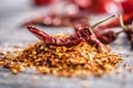 Red chili peppers flakes. Milled spicy peppers on kitchen table Royalty Free Stock Photo