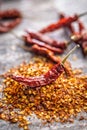 Red chili peppers flakes. Milled spicy peppers on kitchen table Royalty Free Stock Photo
