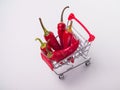 red chili peppers in a food basket on wheels. red peppers on a white