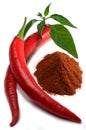 Red chili peppers with leaves and chili powder Royalty Free Stock Photo