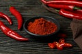 Red chili peppers and powder on rustic wooden background Royalty Free Stock Photo