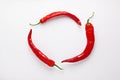 Red chili peppers on white  wood background. Hot spicy food ingredient. Circle frame. Top view Royalty Free Stock Photo