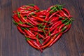 Red chilli peppers on wooden table placed in shape of heart