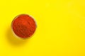 Red chilli powder in glass bowl on yellow background. top view Royalty Free Stock Photo