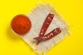 Red chilli powder in glass bowl on yellow background. top view Royalty Free Stock Photo