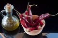 red chillies and olive oil in a jar of clay on a black background Royalty Free Stock Photo
