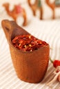 Red chillies paper flakes in curved wooden bowl