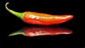 Red chilly. Red hot chilli peppers in black background. Red chilli. Red chilly with black background on reflection surface. Royalty Free Stock Photo