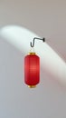 Red chinese lantern hanging on wall hook with dramatic light shadow on ceiling creating festive oriental atmosphere Royalty Free Stock Photo