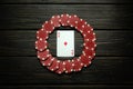 Red chips and ace of diamonds playing card on a black vintage table. Low key concept of luck or winning in poker club Royalty Free Stock Photo