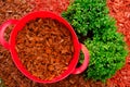 Red chips mulching in red silicone bucket in a garden near a boxwood bush. Mulching the soil in the garden. Royalty Free Stock Photo