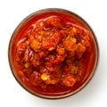 Red chopped chilli peppers in oil in glass bowl.