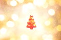 Red christma tree outline on yellow, gold, and white color bokeh background.