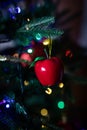 Red christmas ball apple shaped hanging on a christmas tree with blurred lights on background Royalty Free Stock Photo