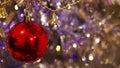 Red christmas ball decoration on glittering background. Dimension 16:9.