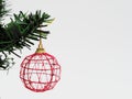 Red Christmas ball hanged on green christmas pine tree branch on white background Royalty Free Stock Photo