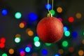 Red christmas ball hanging on gold ribbon with colorful bokeh background Royalty Free Stock Photo