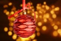 red christmas ball hanging on ribbon with bow, on golden bokeh background with clipping path Royalty Free Stock Photo