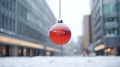 Red Christmas ball hanging on a snowy street in a winter city Christmas ball closeup. Christmas abstract background