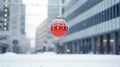 Red Christmas ball hanging on a snowy street in a winter city Christmas ball closeup. Christmas abstract background