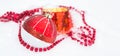 Red Christmas ball on natural white snow with square beads and burning candle in a glass candlestick. Christmas, New year outdoor Royalty Free Stock Photo