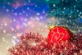 Red Christmas ball under the tree and tinsel.Christmas decorations. Royalty Free Stock Photo