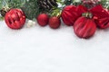 Red Christmas balls, baubles with ribbon and green fir branches, pine cones, on white snow background. Winter holidays. Christmas Royalty Free Stock Photo