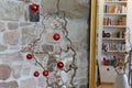 Red christmas balls at a branch in front of a stone wall in a loft apartment, reflections in a mirror with golden frame