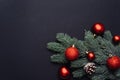 Red Christmas balls on a branch of a Christmas tree on a black background. Greeting card template, web banner mockup. Flat lay, Royalty Free Stock Photo