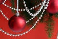 Red christmas balls with garland hang on a red background