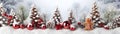 Red Christmas balls and gingerbread piece in a row with trees covered with snow. Royalty Free Stock Photo