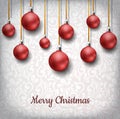 Red Christmas balls hanged on golden ribbon, in front of floral pattern decoration background