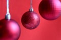 Red christmas balls hanging on a red background