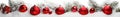 Red Christmas balls in a row with white trees covered with snow and snowfall. Royalty Free Stock Photo