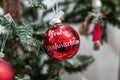 A red christmas ball with the writing `Frohe Weihnachten` on it. Weihnachtskugel mit Frohe Weihnachten.