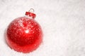 Red Christmas bauble on a bed of snow Royalty Free Stock Photo