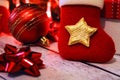 Red Christmas bauble, ribbon bow and the sock put on the wooden table Royalty Free Stock Photo