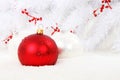 Red Christmas bauble with white balls in snow