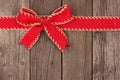 Red Christmas bow and ribbon top border on old wood Royalty Free Stock Photo