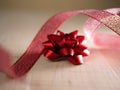 Red Christmas bow with ribbon on wooden background