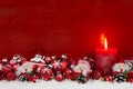 Red christmas candle with balls and imp on wooden background. Royalty Free Stock Photo