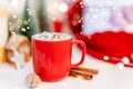 Red Christmas cocoa mug with marshmallow on a background with gingerbread. Copy space banner