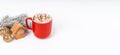 Red Christmas cocoa mug with marshmallow on a white background with gingerbread. Copy space banner.