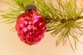 Red Christmas cone on a Christmas tree against the background of shining garlands. Red cone surrounded by branches of the Christma Royalty Free Stock Photo