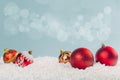 Red glass Christmas balls in the snow on a blue background with bokeh lights. happy new year card Royalty Free Stock Photo