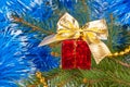 Red Christmas gift with a bow under the Christmas tree Royalty Free Stock Photo