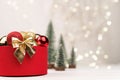 Red Christmas gift box with a gold bow and deer on the background of bokeh Royalty Free Stock Photo