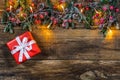 Red Christmas gift with natural green border and lights. Royalty Free Stock Photo
