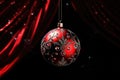 Red Christmas glass ball hanging on blurred black snowy background with bokeh golden lights. Royalty Free Stock Photo